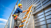 Worker using an industrial ladder for safe building maintenance