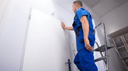 Worker safely using a steel step ladder indoors